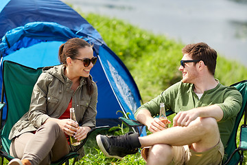 Image showing happy couple drinking beer at campsite tent