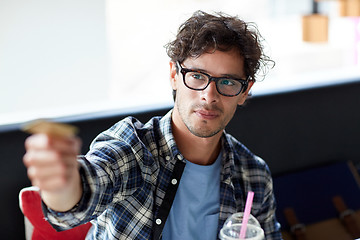 Image showing happy man paying with credit card at cafe