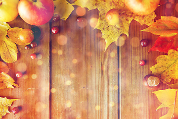 Image showing frame of autumn leaves, fruits and berries on wood