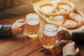 Image showing close up of hands with beer mugs at bar or pub