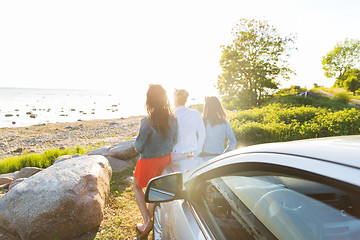 Image showing happy teenage girls or women near car at seaside