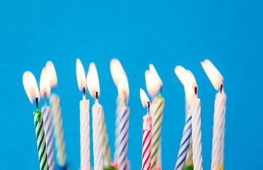 Image showing birthday candles burning over blue background