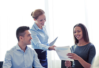 Image showing smiling business people with papers in office