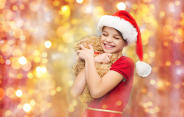 Image showing smiling girl in santa helper hat with teddy bear