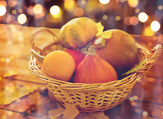 Image showing close up of pumpkins in basket on wooden table