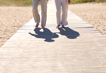 Image showing close up of senior couple walking on summer beach