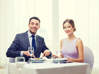 Image showing smiling couple eating appetizers at restaurant