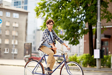 Image showing young hipster man with bag riding fixed gear bike