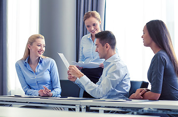 Image showing smiling business people with papers in office