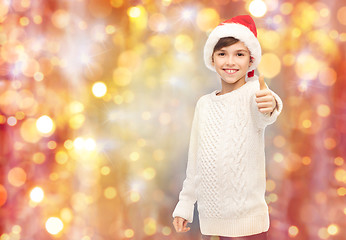 Image showing smiling happy boy in santa hat showing thumbs up