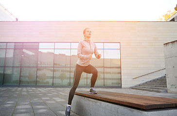 Image showing woman making step exercise on city street bench