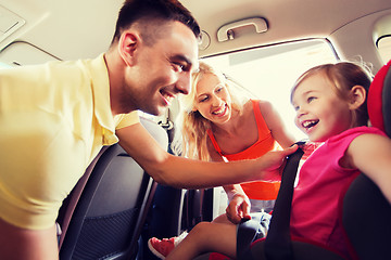 Image showing happy parents fastening child with car seat belt