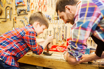 Image showing father and son with hammer working at workshop