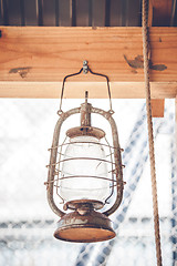 Image showing Vintage western lantern hanging on a wooden plank