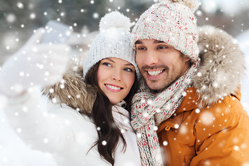 Image showing happy couple taking selfie by smartphone in winter