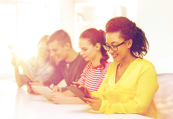 Image showing smiling students looking at tablet pc at school