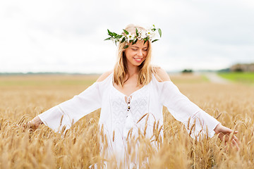 Image showing happy young woman in flower wreath on cereal field