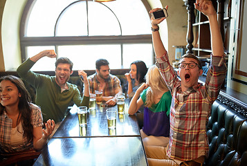 Image showing friends with beer watching football at bar or pub