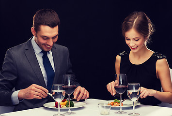 Image showing smiling couple eating main course at restaurant