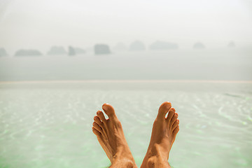 Image showing closeup of male feet over sea and sky on beach