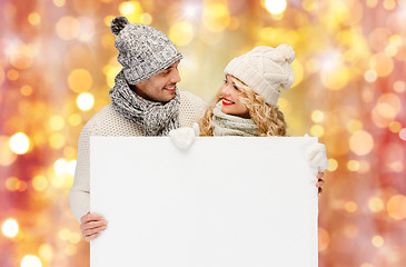 Image showing couple in winter clothes with blank white board