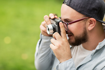 Image showing close up of man with camera shooting outdoors