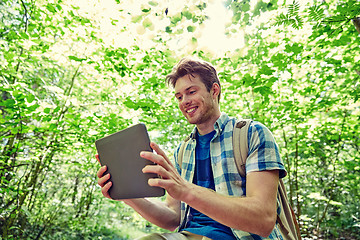 Image showing happy man with backpack and tablet pc in woods