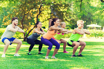 Image showing group of friends or sportsmen exercising outdoors