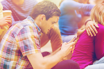 Image showing group of smiling students with smartphone