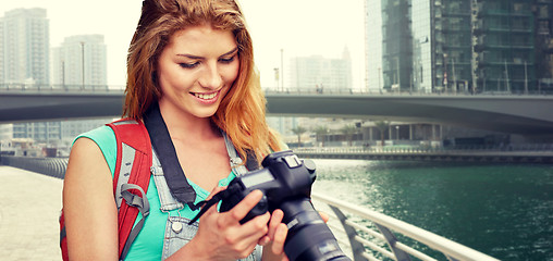 Image showing woman with backpack and camera over dubai city