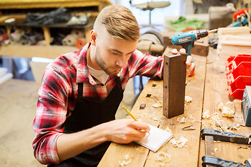 Image showing carpenter working with wood plank at workshop