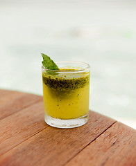 Image showing glass of fresh juice or cocktail on table at beach