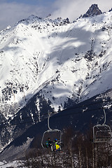 Image showing Skiers on ski lift in winter sun mountains