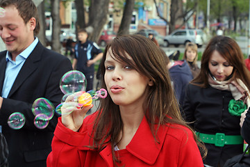 Image showing The young girl starts up soap bubble