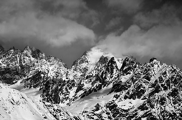 Image showing Black and white snowy rocks in clouds at sun winter day