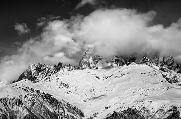 Image showing Black and white snow mountains in fog at sun winter day