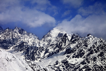 Image showing Snowy rocks in clouds at sun winter day