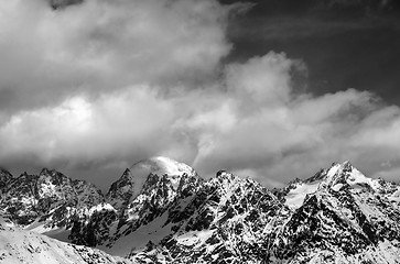 Image showing Black and white view on snow mountaims in clouds at sun winter d