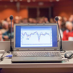 Image showing Computer and microphone on rostrum at business event.