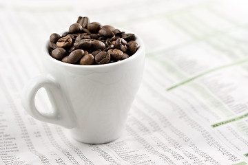 Image showing Classic espresso cup on financial pages, shallow depth of field