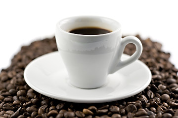 Image showing Classic white espresso cup on coffee beans