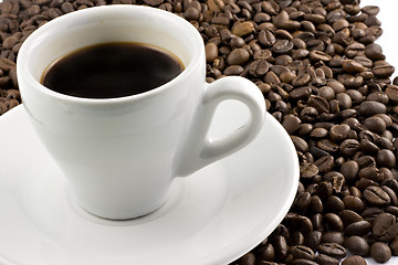 Image showing Classic white espresso cup on coffee beans
