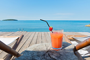 Image showing Wooden floor with chaise-longues and cocktail