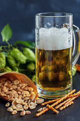 Image showing Salted sticks, peanuts and mug of beer.