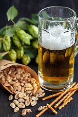 Image showing Bag of peanuts and mug of beer.