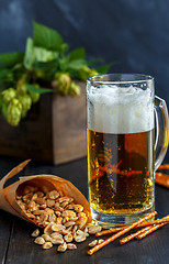 Image showing Mug of beer, peanuts and straws.