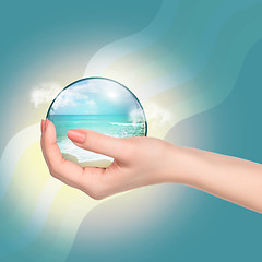 Image showing Hand holding crystal ball with beach and sea