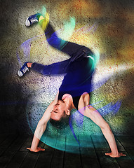 Image showing Break dancer doing handstand against colorful wall background