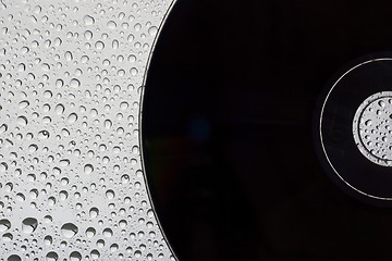 Image showing Black disc on water drops background