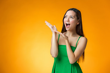 Image showing The surprised Chinese girl on yellow background